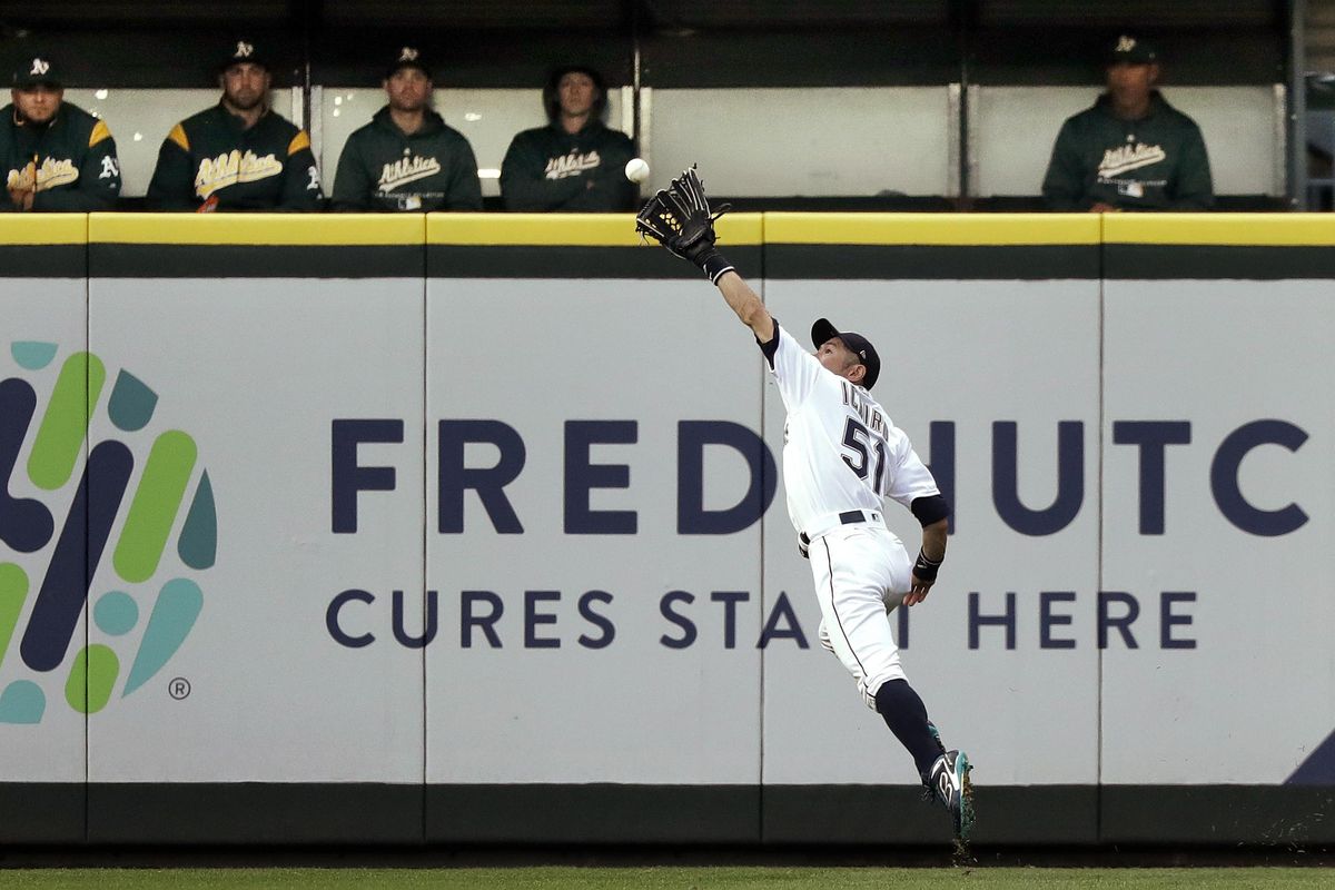 Seattle right fielder Ichiro Suzuki catches a fly ball from Oakland’s Matt Chapman during the second inning Wednesday in Seattle. (Elaine Thompson / AP)