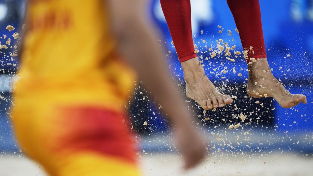 Feet and sand fly during a beach volleyball match between Norway and Spain at the Summer Olympics, Monday in Tokyo.  (Petros Giannakouris)