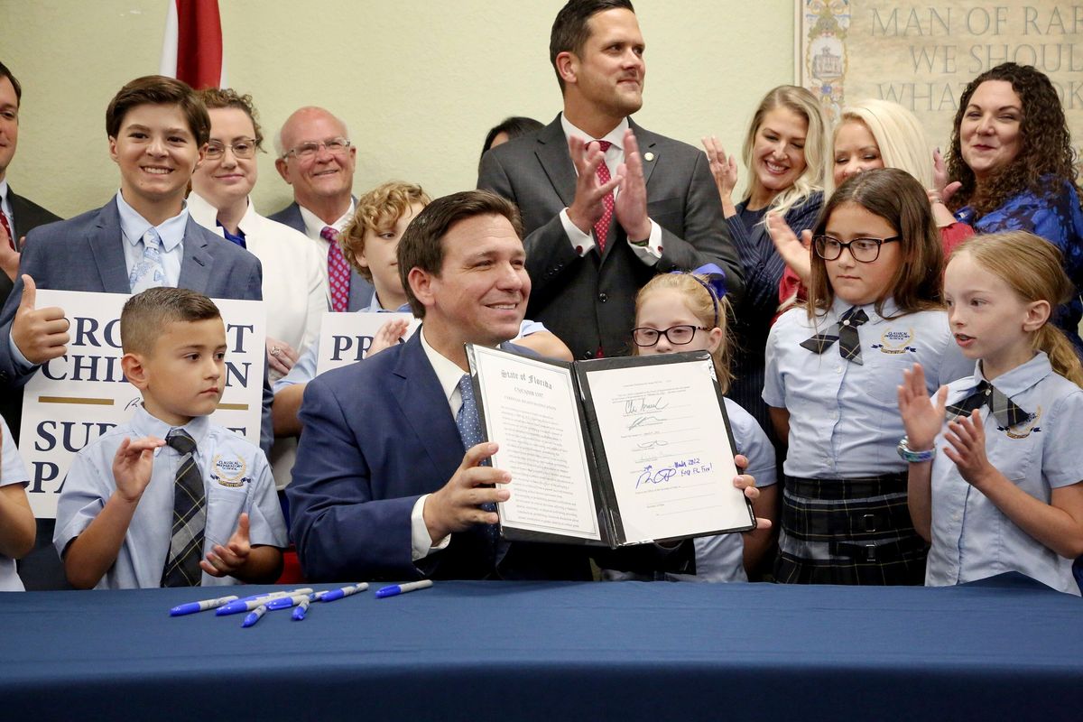Florida Gov. Ron DeSantis displays the signed Parental Rights in Education during a news conference Monday at Classical Preparatory school in Shady Hills.  (Douglas R. Clifford)
