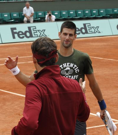 Novak Djokovic (facing) greets Roger Federer on Friday. (Associated Press)