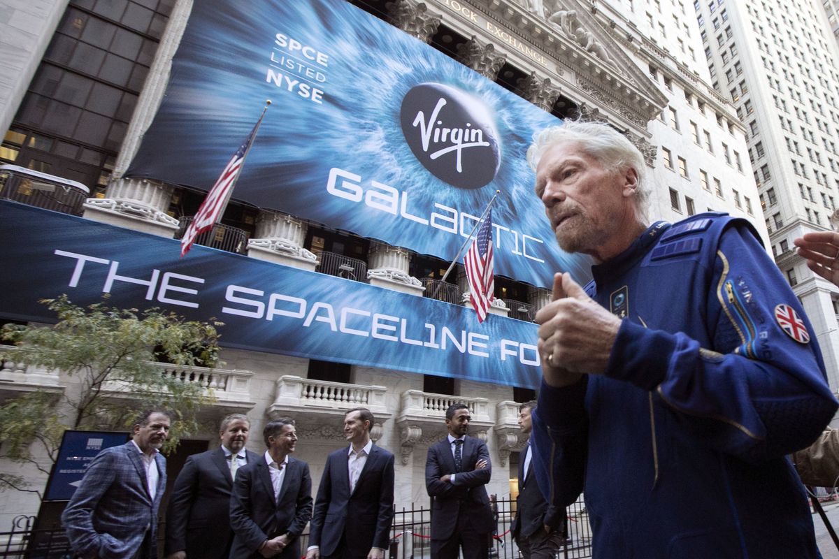 FILE - In this Monday, Oct. 28, 2019 file photo, Richard Branson, right, founder of Virgin Galactic, and company executives gather for photos outside the New York Stock Exchange before his company