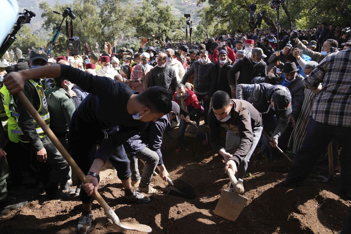 Workers cover the grave dug for 5-year-old Rayan during his funeral after his body was retrieved from a deep well, in the village of Ighran in Morocco