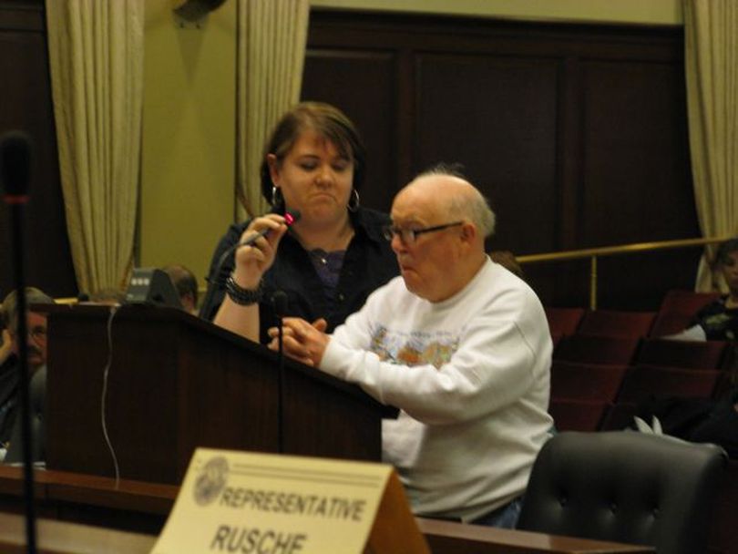 Frank Roundy, who speaks with difficulty, brought a helper to the podium to help him get his message across to lawmakers that he doesn't want his developmental therapy services cut off just because he's past the age of 45. (Betsy Russell)