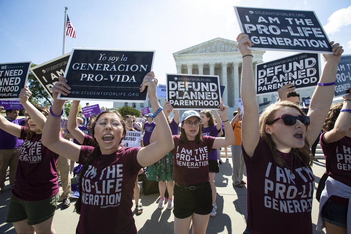 In this June 25, 2018 photo, pro-life and anti-abortion advocates demonstrate in front of the Supreme Court in Washington. Republican lawmakers in at least a half dozen GOP-controlled states already are talking about copying a Texas law that bans abortions after a fetal heartbeat is detected. The law was written in a way that was intended to avoid running afoul of federal law by allowing enforcement by private citizens, not government officials.  (J. Scott Applewhite)