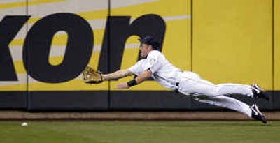 
Anaheim's Darin Erstad picked up his first triple of the year when Seattle center fielder Jeremy Reed came up empty on this dive. 
 (Associated Press / The Spokesman-Review)