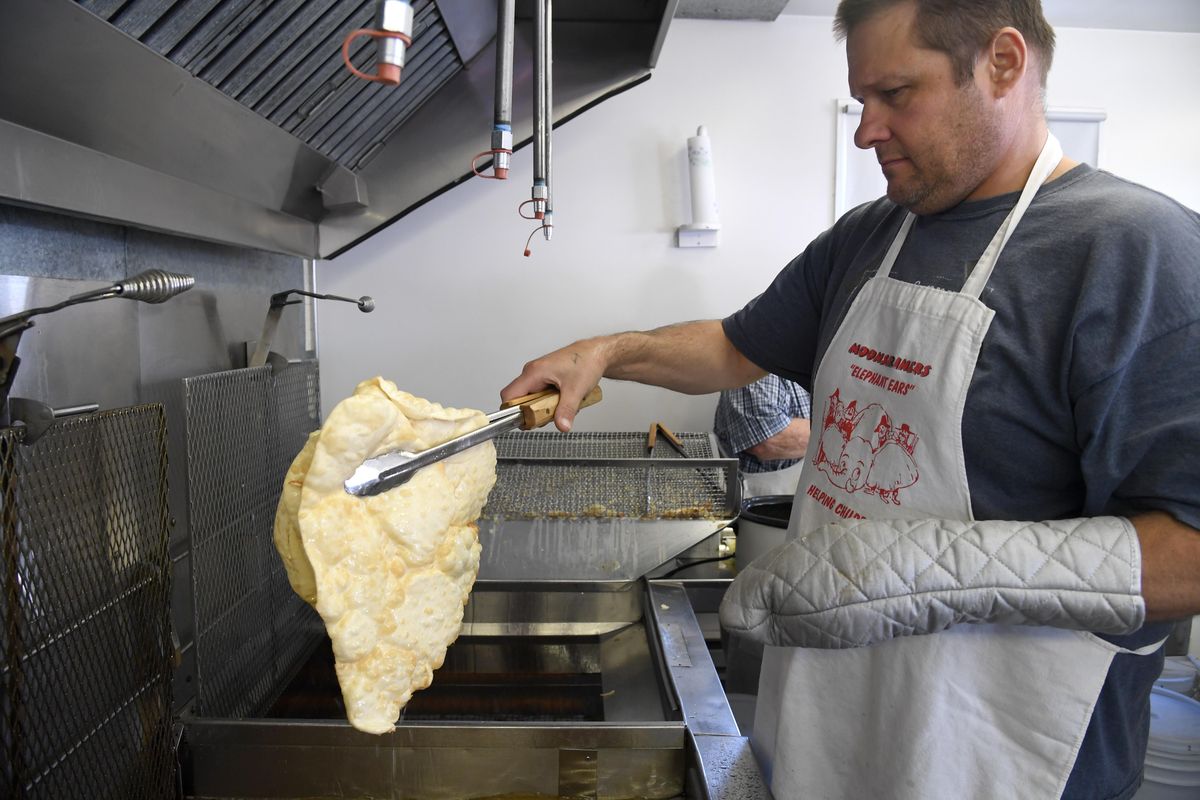 Volunteer cook Barry Newman lets a deep-fried elephant ear drain before placing it on a rack to be buttered and sprink’ed with cinnamon and sugar on Monday, Sept. 12, 2016. (Jesse Tinsley / The Spokesman-Review)