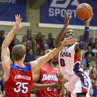 Gonzaga guard Gerard Coleman (0) gets around Dayton's Matt Kavanaugh (35) and Dyshawn Pierre, center, to take a shot in the first half of an NCAA college basketball game at the Maui Invitational on Monday in Lahaina, Hawaii. (Associated Press)