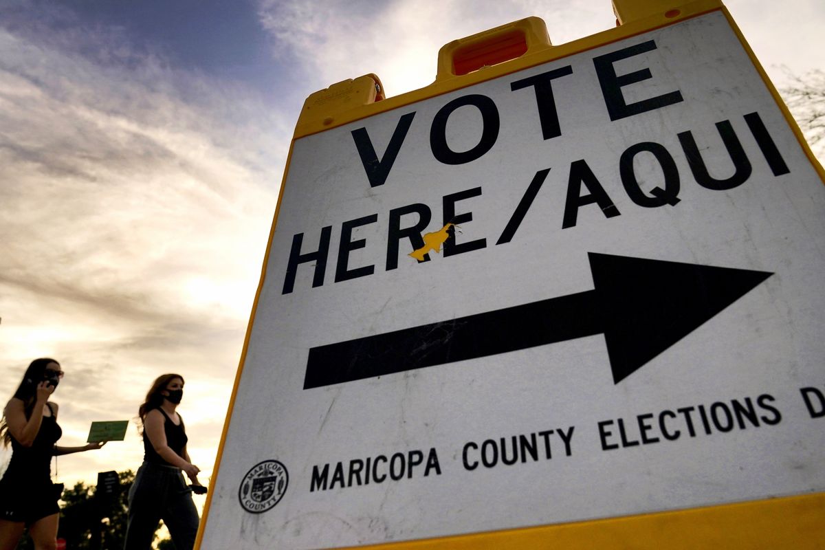 Voters deliver their ballot to a polling station on Nov. 3 in Tempe, Ariz.  (Matt York)