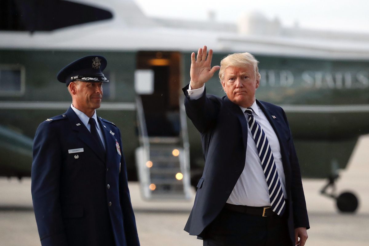 President Donald Trump waves to members of the media after arriving on Air Force One, Friday, Aug. 31, 2018 at Andrews Air Force Base in Md. Watching is Air Force Col. Samuel Chesnut. (Pablo Martinez Monsivais / Associated Press)