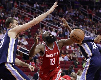 Houston’s James Harden (center) loses the ball on a drive to the basket under pressure from Memphis Grizzlies center Marc Gasol (left) and forward Dillon Brooks during Saturday’s game. (Michael Wyke / Associated Press)