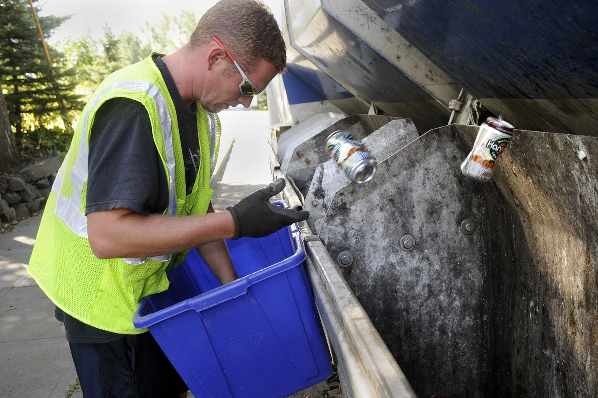 Andy Montgomery sorts through recyclables curbside near the corner of 12th Avenue and Cherry Street on Friday. (Dan Pelle)