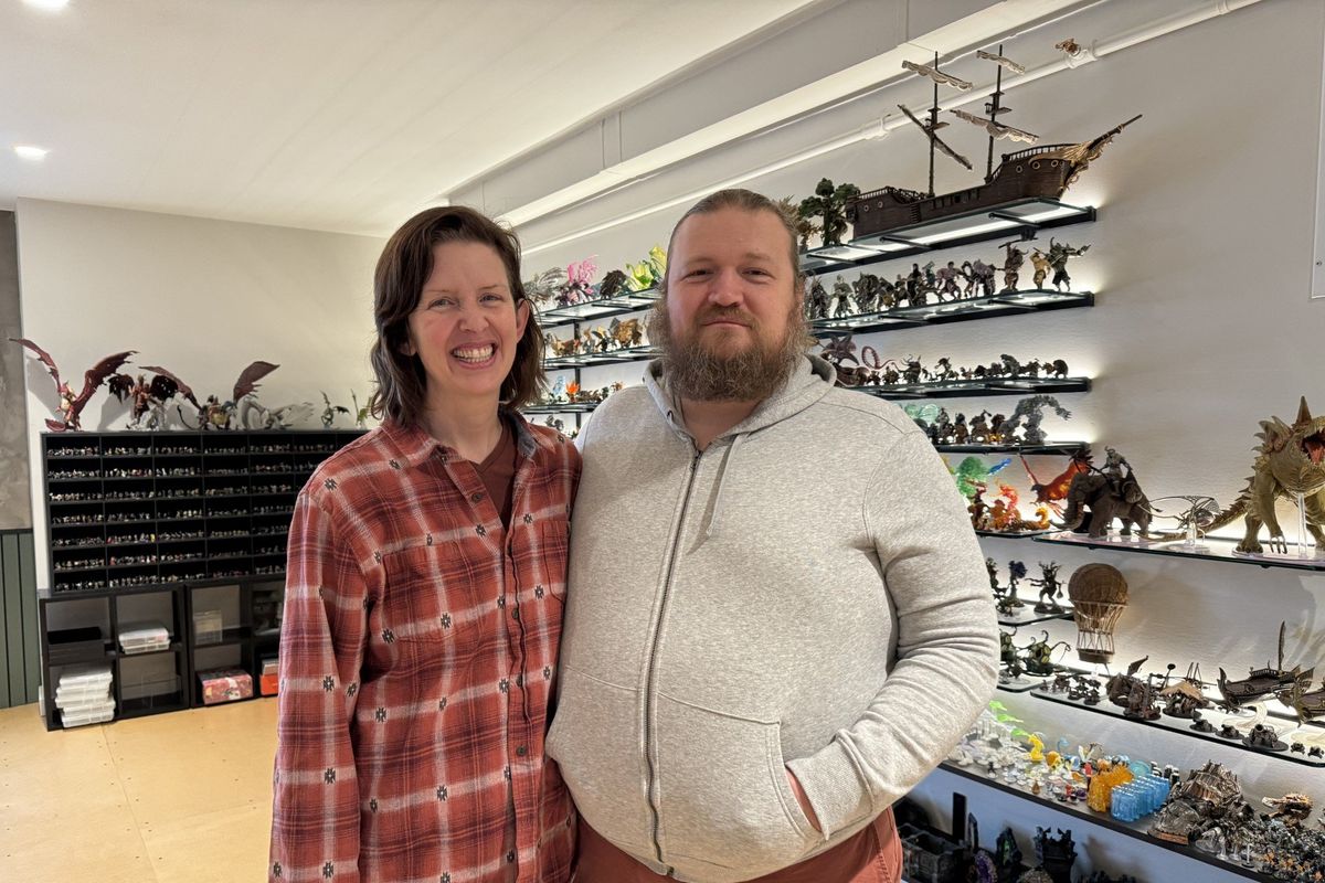 Wife and husband Rebekah Miller, left, and Seth Miller, who co-own Bear Totem and Pigasus, are pictured in front of the wall of miniatures in Bear Totem on Feb. 1 in Spokane.  (Alisa Volz / The Spokesman-Review)