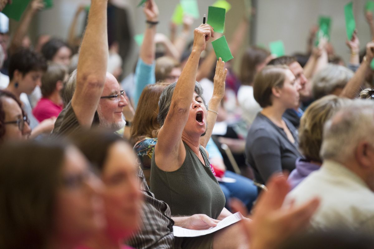 Members of the audience hold up green or red cards to indicate their agreement or displeasure with what they are hearing during the town hall meeting of Rep. Cathy McMorris Rodgers on Thursday, Aug. 10, 2017 at Cataldo Hall at Gonzaga University. (Jesse Tinsley / The Spokesman-Review)