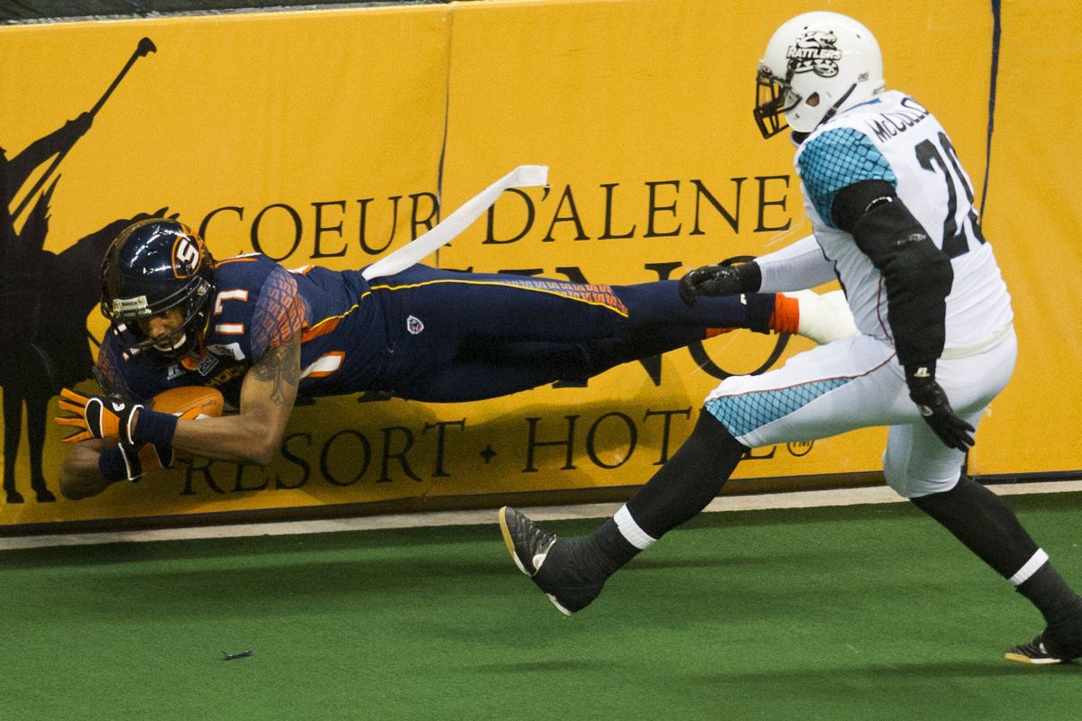 Spokane Shock receiver Adron Tennell stretches for yardage against Arizona defender Kevin McCullough during Friday’s game at the Arena. (Colin Mulvany)