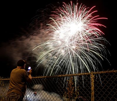 A man watches a fireworks display for Independence Day at Worlds of Fun amusement park Monday, July 3, 2017, in Kansas City, Mo. (Charlie Riedel / Associated Press)