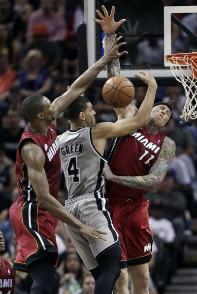 Spurs’ Danny Green, center, drives into Heat’s Chris Anderson while Chris Bosh defends from behind in Sunday’s game. (Associated Press)