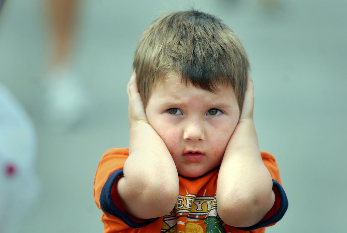 Cody Sprecker, 4, of Reardan, tries to shut out the roar of military fighter jets. (Jesse Tinsley / The Spokesman-Review)