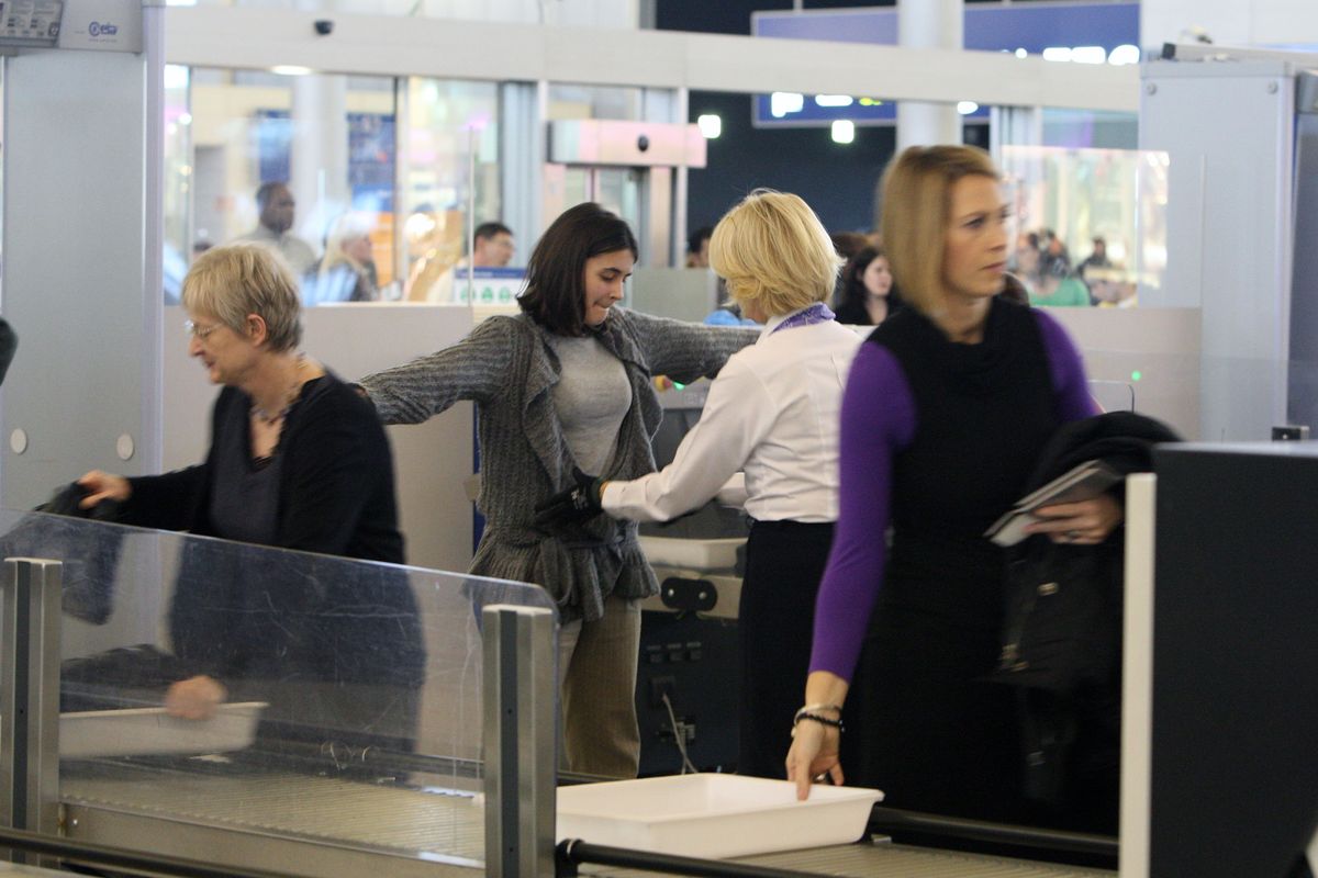A woman is searched before boarding a U.S.-bound plane Wednesday in Paris.  (Associated Press)