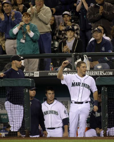 Seattle Mariners' Dustin Ackley steps from the dugout to wave to fans after he hit a solo home run in the second inning of an interleague baseball game against the Philadelphia Phillies, Saturday, June 18, 2011, in Seattle. The shot was his first major-league home run. (Ted Warren / Associated Press)