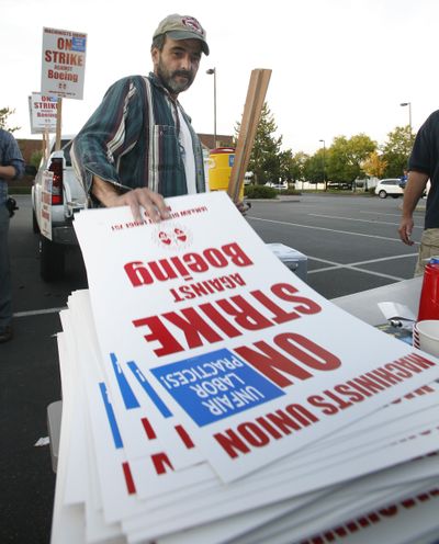 Brad Lee, 47, grabs a picket sign at Machinists Union Hall in Seattle on Friday.  (Associated Press / The Spokesman-Review)