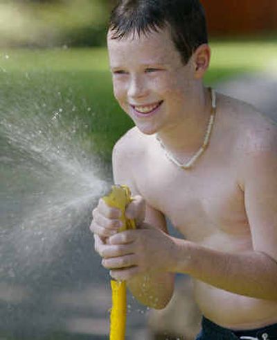 
A couple of water bottles, a hose and a lot of imagination is all the kids need to have fun and stay cool outside. 
 (Knight-Ridder Tribune / The Spokesman-Review)