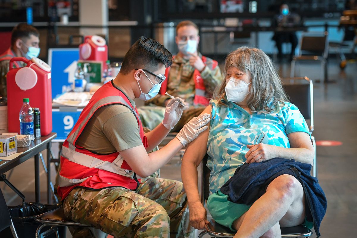 Joan Mattson, 64, gets her first Moderna vaccination from Wendell Tu of the Army National Guard, Friday, April 2, 2021 at the Spokane Arena. (DAN PELLE/THE SPOKESMAN-REVIEW)