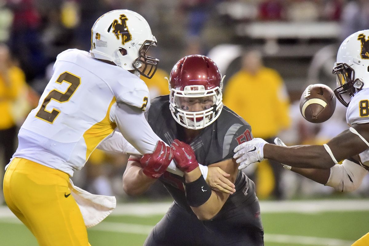 Wyoming quarterback Cameron Coffman gets wrapped up by Washington State defensive end Hercules Mata'afa during the second half of last season’s matchup in Pullman. (Tyler Tjomsland / The Spokesman-Review)