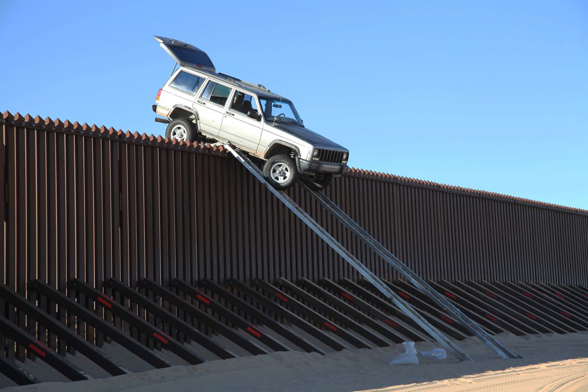 In this photo provided by the U.S. Customs and Border Protection, a silver Jeep Cherokee that suspected smugglers were attempting to drive over the U.S.-Mexico border fence is stuck at the top of a makeshift ramp early Wednesday, Oct. 31, 2012 near Yuma, Ariz. U.S. Border Patrol agents from the Yuma Station seized both the ramps and the vehicle, which stalled at the top of the ramp after it became high centered. The fence is approximately 14 feet high where the would-be smugglers attempted to illegally drive across the border. The two suspects fled into Mexico when the agents arrived at the scene. (U.s. Customs And Border Protection)
