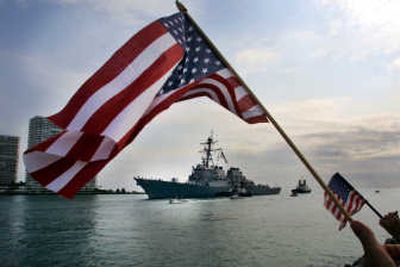 
United States flags frame the USS Cole as spectators line the jetty to watch the Navy destroyer make its way to Port Everglades in Florida.Associated Press
 (File Associated Press / The Spokesman-Review)