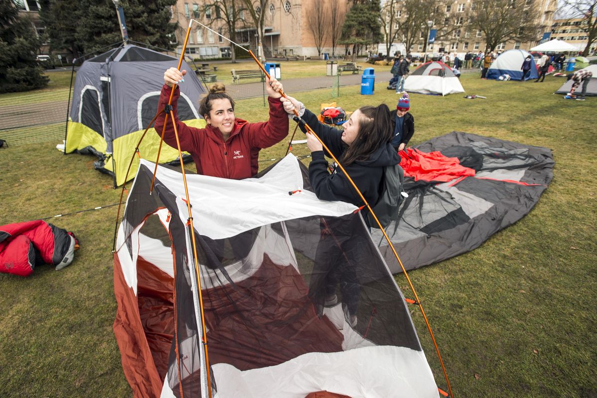 Gonzaga University freshmen Kaitlin Cowell, 19, left and Sam Lembo, 19, set up their tent in Herak Field, Friday, Feb 2, 2018. A Gonzaga University tradition, students, in order to obtain tickets to the basketball game with BYU on Saturday in the Kennel, set up a tent city and camp overnight. (Colin Mulvany / The Spokesman-Review)