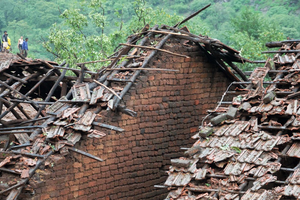 Homes stand damaged as rescuers work at the site of a landslide in Malin village, in the western Indian state of Maharashtra, Wednesday, July 30, 2014.
 (Nitin Lawate / Associated Press)