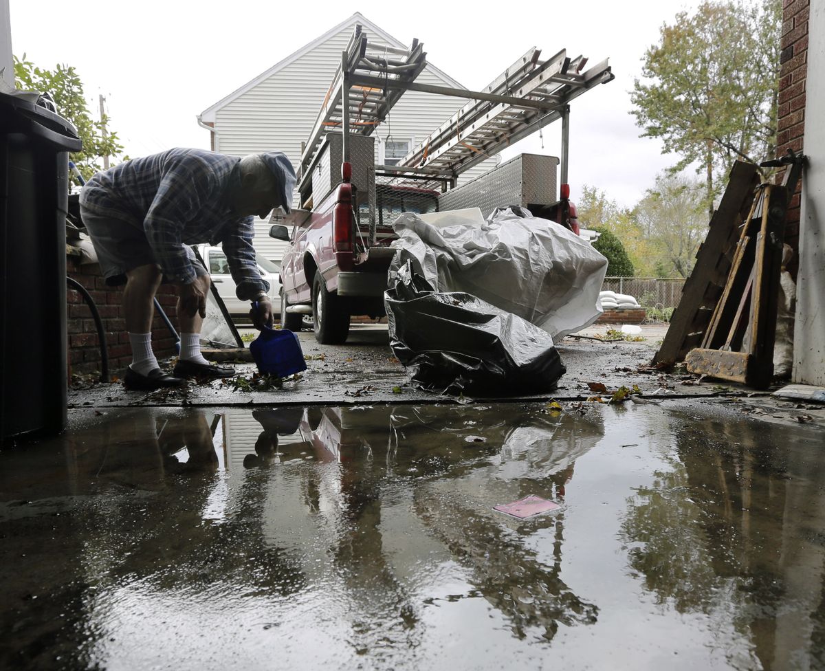 Charlie DiBuono cleans mud and debris from his flooded garage in the wake of superstorm Sandy on Thursday, Nov. 1, 2012, in Little Ferry, N.J. Surprise coastal surge floods caused by the storm battered Little Ferry, Moonachie and some other towns along the Hackensack River in Bergen County _ all areas unaccustomed to flooding. (Mike Groll / Associated Press)