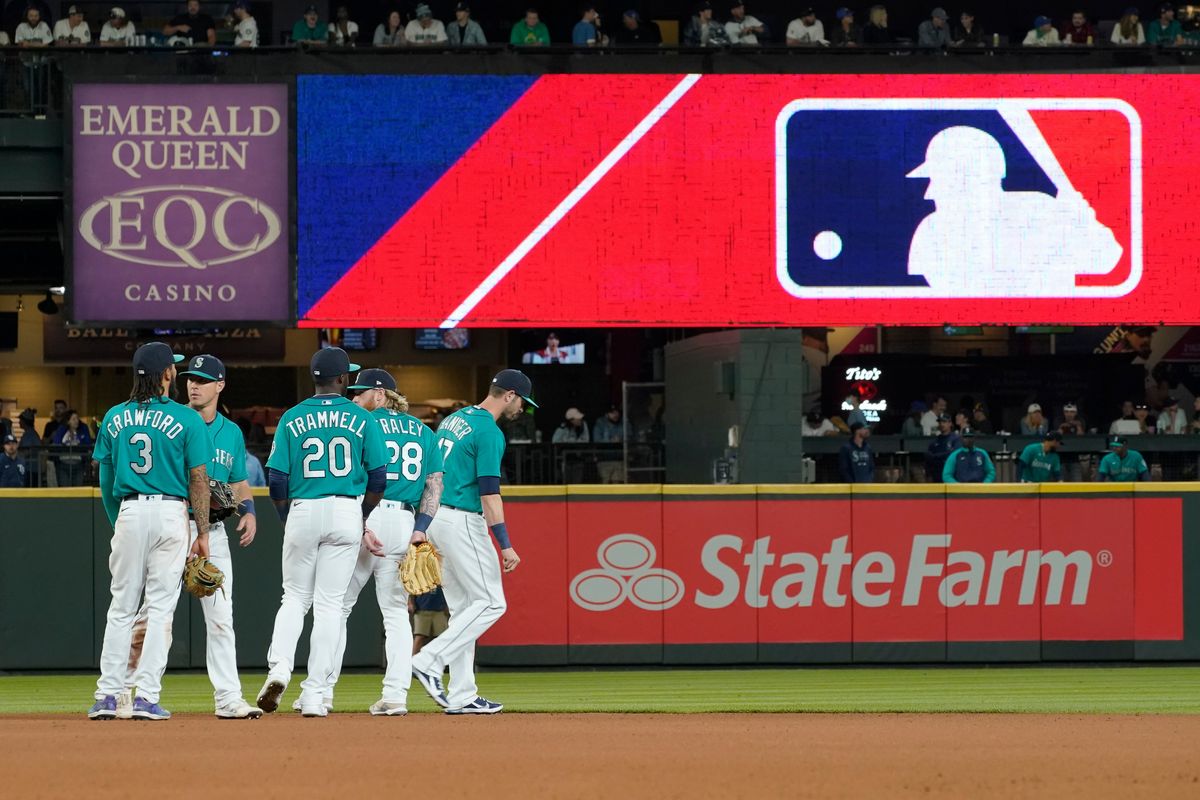 Seattle Mariners gather as the MLB logo is shown during a review of an attempted catch by right fielder Mitch Haniger of a ball hit by Tampa Bay Rays
