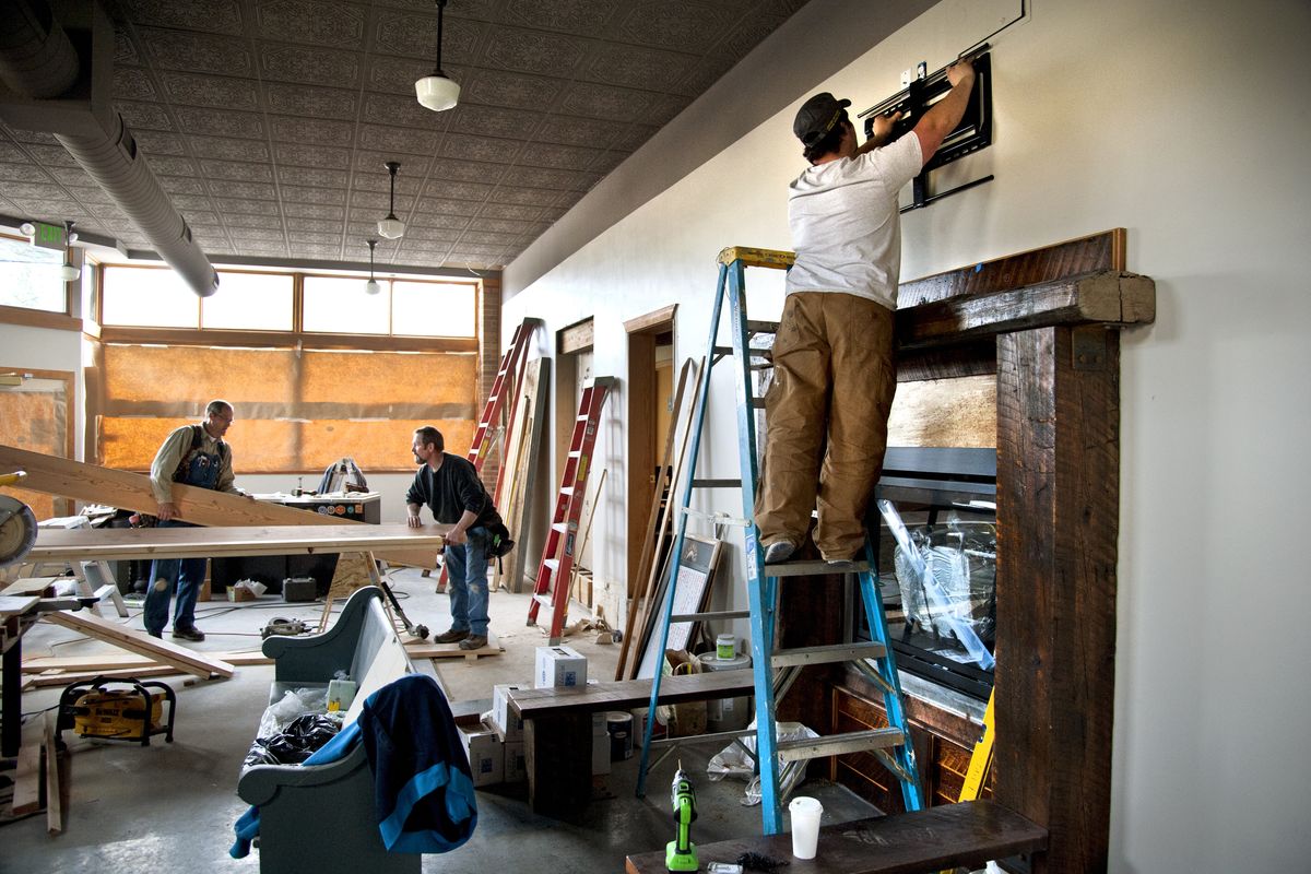 Lantern Tap House co-owner James Pearson, right, mounts a TV bracket as Kevin Ruehl, left, and Bob Voves, of Ruehl Construction, build a handicapped-accessible ramp in the former Perry Street Cafe building on Thursday in Spokane. (Dan Pelle)