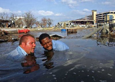 
Workers for the Gulfport Water and Sewage Department attempt to change a valve on a drinking water line which had burst causing a flood in Gulfport, Miss., on Tuesday. 
 (Associated Press / The Spokesman-Review)