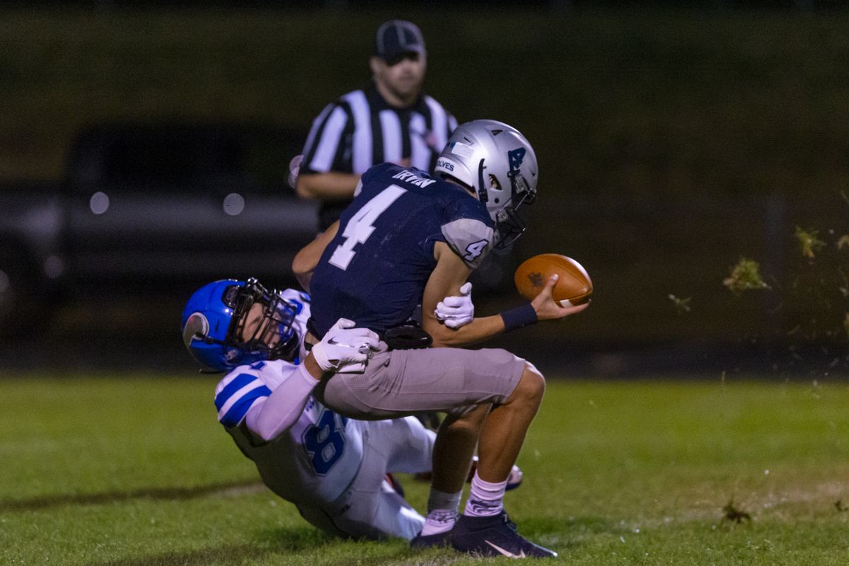 Coeur d’Alene’s Cameren Cope pulls down Lake City quarterback Chris Irvin in the Vikings’ 40-13 win over the Timberwolves on Friday.  (Cheryl Nichols/For The Spokesman-Review)