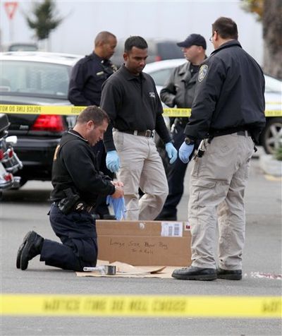 San Leandro police officers gather evidence at the scene of a shooting Friday morning at Walmart on Hesperian Boulevard in San Leandro, Calif. Gunfire rang out about 1:50 a.m. and a man was shot in a robbery attempt. Despite major injuries, police said he was in stable condition.  (Jane Tyska / Bay Area News Group)