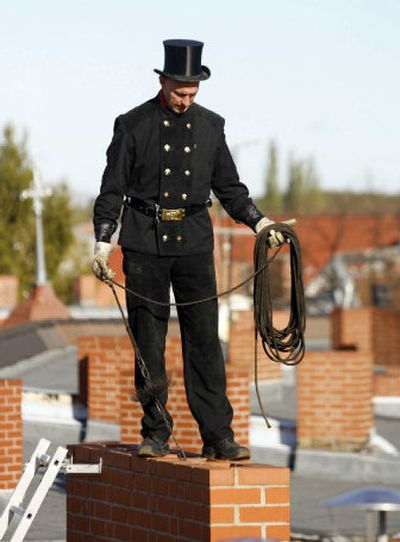 German chimney sweeper Karsten Valentin poses on a chimney at a roof at the district Reinickendorf in the German capital Berlin on Friday. 
 (Associated Press / The Spokesman-Review)