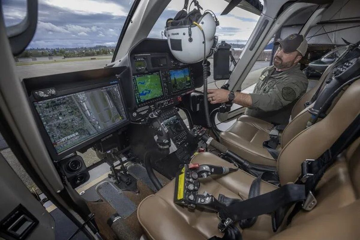 King County sheriff’s Deputy Tony Mullinax talks last week about the instrument panel in the cockpit of a new helicopter the department has acquired. The new Bell 407GXi helicopter has autopilot and other features the previous helicopter the department uses does not. They are located at the Renton Municipal Airport.  (Ellen M. Banner/Seattle Times)