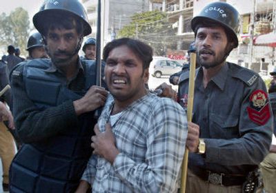 
Pakistani police officers detain a protester during an anti-U.S. rally in Rawalpindi, Pakistan, on Friday. Anti-U.S. protests erupted across Pakistan  hours before  President Bush was to arrive. 
 (Associated Press / The Spokesman-Review)