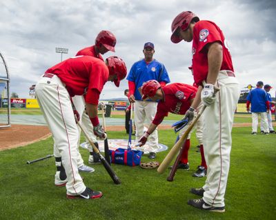 Spokane batting coach Oscar Bernard, center, offers advice to Indians hitters. (Colin Mulvany)
