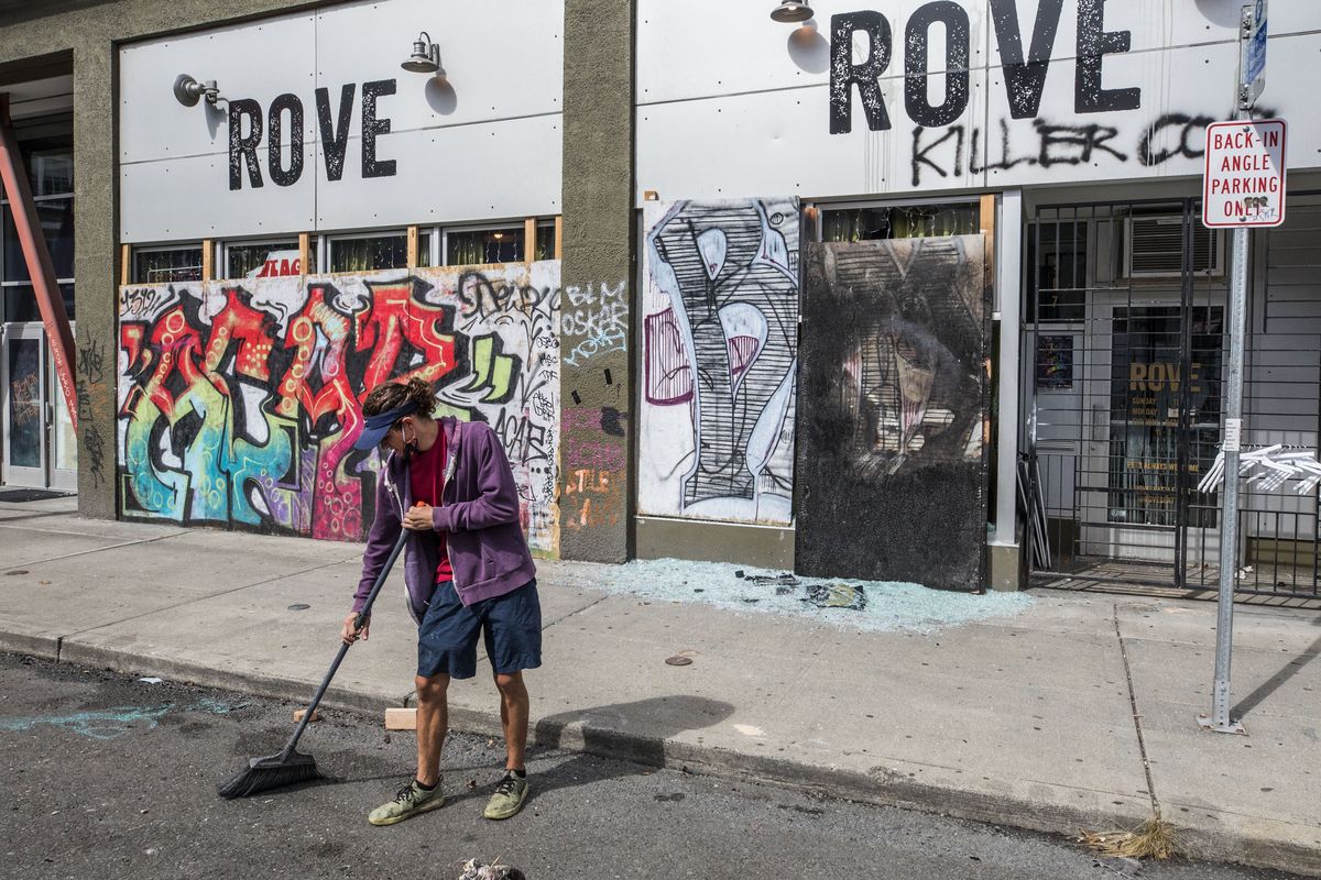 Cleanup outside a clothing store Thursday, July 23, 2020 on 11the Ave. near E. Pike St. in Capitol Hill that was looted and burned, Wednesday night.  (Steve Ringman)