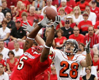 
Louisville's Antoine Sharp, left, was one of the few defenders to keep the ball from OSU's Mike Hass during a Sept. 17 game. 
 (Associated Press / The Spokesman-Review)