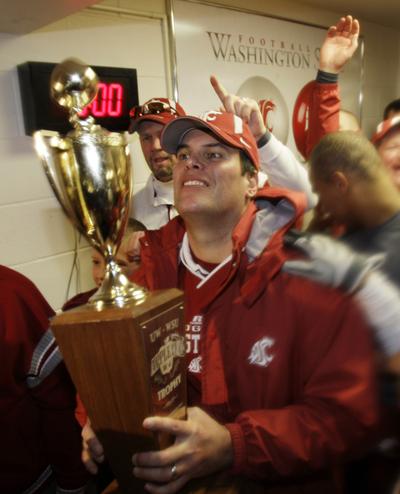 Paul Wulff holds the prize after winning his first Apple Cup as coach of the Cougs.   (Associated Press / The Spokesman-Review)