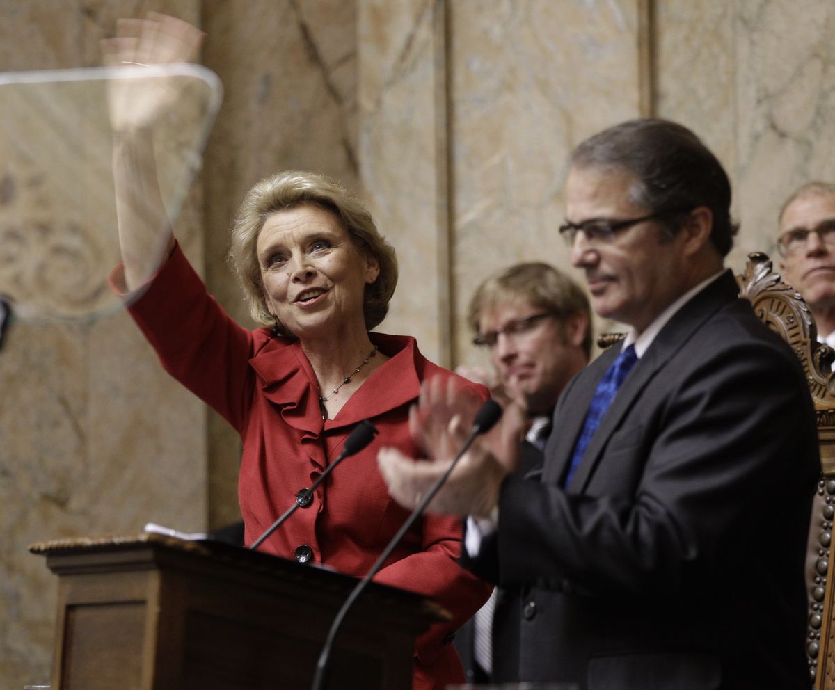 Washington Gov. Chris Gregoire, left, waves to the gallery as she stands with Lt. Gov. Brad Owen, right, prior to giving  her State of the State to a joint session of the WashingtonLegislature, Tuesday, Jan. 11, 2011, at the Capitol in Olympia, Wash. (Ted Warren / Associated Press)