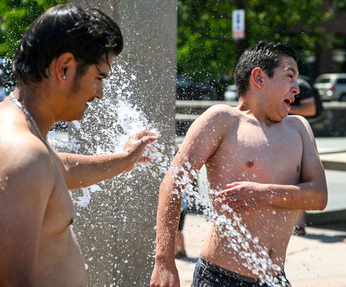 Dominik Martinez, left, splashes his brother, Matthew, as they cool off in the Rotary Riverfront Fountain, Monday, July 8, 2024, in Spokane. Temperatures in Spokane reached 100 or more on Monday, Tuesday and Wednesday.  (DAN PELLE/THE SPOKESMAN-REVIEW)