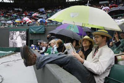 
Associated Press Spectators wait after rain delayed the start of play at the Wimbledon tennis championships Saturday.
 (Associated Press / The Spokesman-Review)