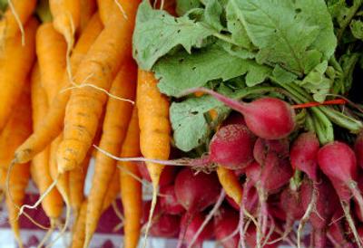 
Radishes and carrots sit at a vendor's stall at the Liberty Lake Farmers' Market recently.
 (Joe Barrentine / The Spokesman-Review)