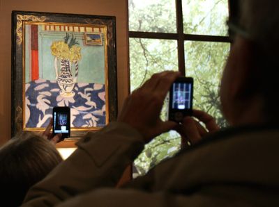 Members of the media  photograph  a 1911 painting by Matisse: “Les coucous, tapis bleu et rose.”  (Associated Press / The Spokesman-Review)