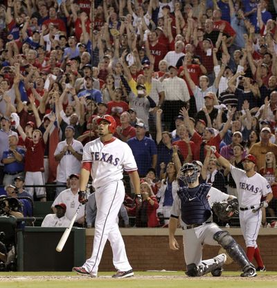 Nelson Cruz of the Rangers watches his historic home run, the first walk-off grand slam in postseason history. (Associated Press)
